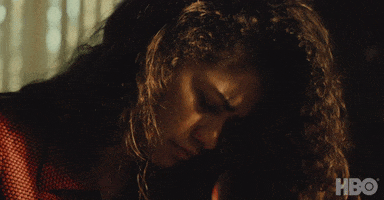 TV gif. Zendaya as Rue on Euphoria looks down, hiding her face with her hair. She has an irritated look on her face until she lifts her head up, and looks up to say, “Okay.” She shrugs her shoulder like its no big deal. 