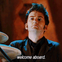 TV gif. David Tennant as the Tenth Doctor in Doctor Who. He says, "Welcome Aboard," while staring at someone with his head cocked upwards and his mouth in a thin line.