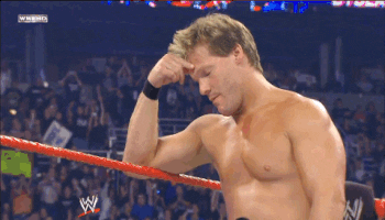 Sports gif. Shirtless WWE wrestler leans on the ropes of the boxing ring with his head in his hand, looking disappointed and ashamed.