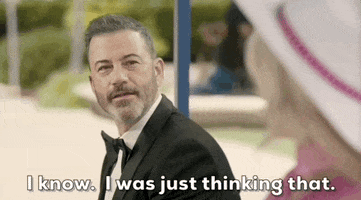 Oscars 2024 GIF. Jimmy Kimmel sits next to Margot Robbie as Barbie on the bus stop bench. He parodies the bus stop bench scene and leans in and enthusiastically says, "I know. I was just thinking that."