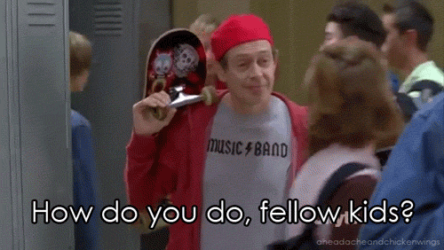 TV gif. Steve Buscemi as Lenny in 30 Rock walks down a school hallway wearing a backwards cap and skateboard over his shoulder. He smiles as he approaches someone in the hall. Text, "How do you do, fellow kids?"