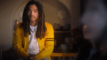 TV gif. Luka Sabbat as Luca from Grownish sits wearing a yellow cardigan. He speaks casually offscreen, punctuating his words with a slight toss of his hands, then glances to the side. Text, "All facts."