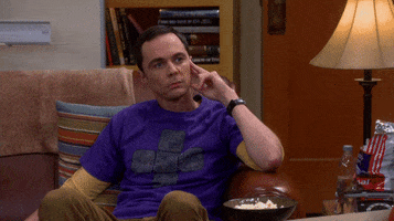 Big Bang Theory gif. Jim Parsons as Sheldon sits on a sofa, straight-faced, touching his hand to his face and then pointing forward and saying "that's my boy!" which appears as text.