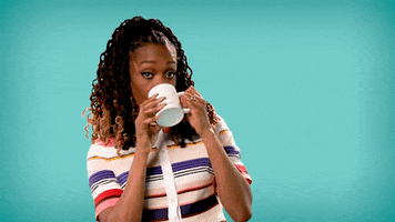 Celebrity gif. Franchesca Ramsey takes a sip from a tea cup and forcefully blinks her eyes  as she lowers the cup. 