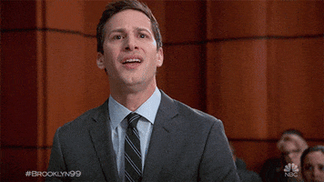 TV gif. Andy Samberg as Jake from Brooklyn Nine-Nine stands at the front of a courtroom in a suit, looking nervous. He nods in our direction, then looks around as he sighs. Text: "Cool." 