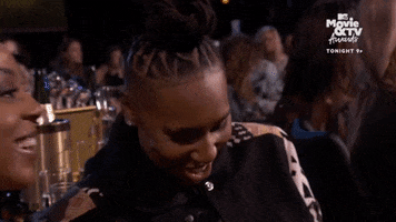 TV gif. Seated at an awards show, Alana Mayo points her finger at something to the side, smiling, while Lena Waithe shakes her head and smiles.