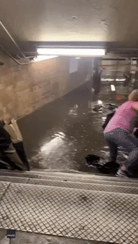 Subway Commuters Wear Trash Bags to Wade Through Thigh-High Floodwaters Amid Heavy Rainfall
