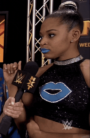 Sports gif. WWE wrestler Bianca Belair walks away from person holding a microphone, giving them the side-eye.