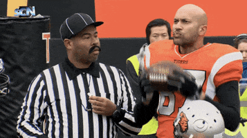 TV gif. Key and Peele are a referee and a football player. Key takes a huge bite out of the football and moans in delicious delight. Peele stares at him, while holding the whistle to his mouth.