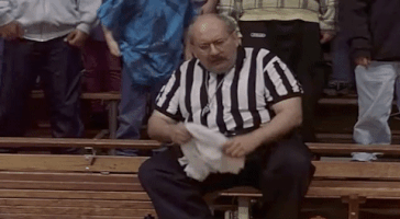 Movie gif. In Air Bud, a referee sits on a bench and covers his head with a towel, appearing defeated.