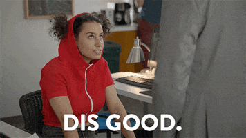 TV gif. Ilana Glazer as Ilana in Broad City sitting forward in an office chair, red hoodie pulled up over her head with her pigtails poking out as she nods and says, "Dis good, dis real good."