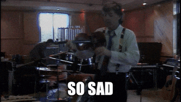Celebrity gif. Paul McCartney is standing in the middle of a recording studio and plays the violin. He plays it gently and the text below reads, "So sad."