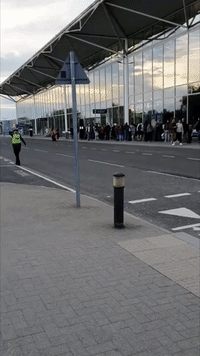 Passengers Wait in Line Stretching Outside Airport