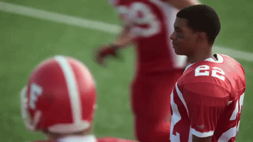 TV gif. Brett Gray as Jamal Turner in On My Block in his football uniform looking back and waving rapidly.