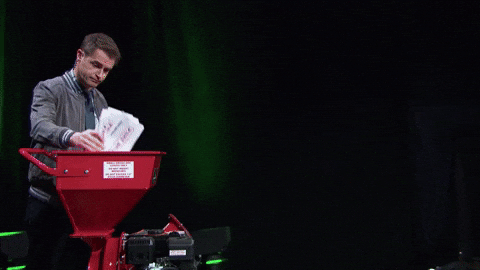 A person feeding sheets of paper into a document shredder