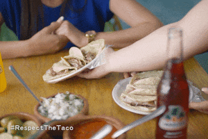 Ad gif. Hand sets a plate of tacos at a table set with taquiza, toppings and yellow and red Jarritos soda bottles. Text on the bottom right reads, "Hashtag Respect The Taco."