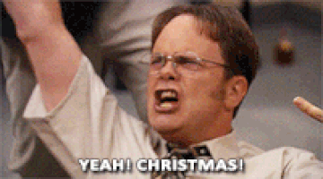 The Office gif. Rainn WIlson as Dwight Schrute has his hands in the air and one hand in a rock n roll symbol. Like a battle cry, he yells, “Yeah, Christmas!” 
