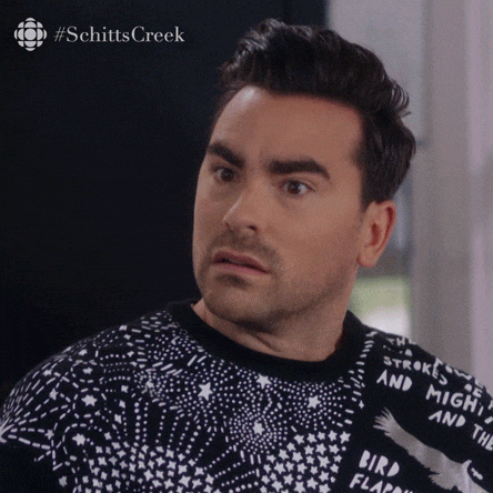 Schitt’s Creek gif. Dan Levy as David nods lightly as if absorbing some troubling information. His eyes dart around nervously, then he composes himself for a second to smile and speak. Text, "Yeah."