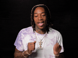 Celebrity gif. Wiz Khalifa doing a happy dance, sticking his tongue out.