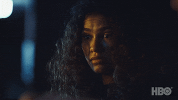 TV gif. Zendaya as Rue on Euphoria looks down at something with wide, nervous eyes. She looks out of the corner of her eye without barely moving her body.