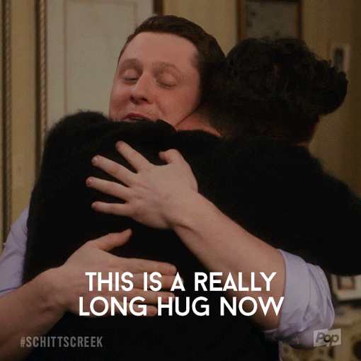 Schitt's Creek gif. Dan Levy as David and Noah Reid as Patrick are in a deep hug. David is blissful with his eyes closed and Patrick says, "This is a really long hug now," while David responds, "Just one more minute."