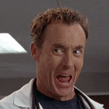 TV gif John C McGinley as Dr Cox on Scrubs laughs in wide-mouthed glee and shakes his head in jubilation