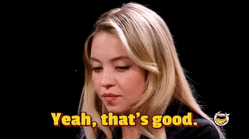 Celebrity gif. Sydney Sweeney is on Hot Ones and she nods solemnly and says, "Yeah, that's good."