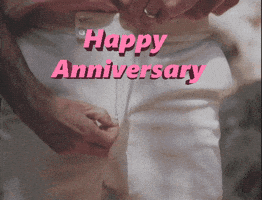 Video gif. Close-up of a man unzipping his pants, reaching in, and pulling out a pink flower. Text, "Happy anniversary."
