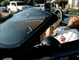 Music video gif. LL Cool J in the Luv U Better Music video slowly pulls up in a black convertible car. He looks up, leaning his head back. He holds a flip phone in his hands and flips it shut.