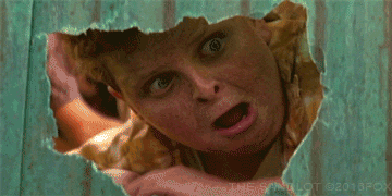 Movie gif. Patrick Renna as Ham in The Sandlot. He peers through a hole in the gate and freaks out at what he sees, screaming and yelping but unable to take his eyes off it.