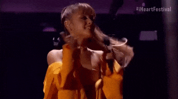 Celebrity gif. Ariana Grande blows a kiss and waves to the audience after performing at the iHeartRadio Music Festival in 2016.
