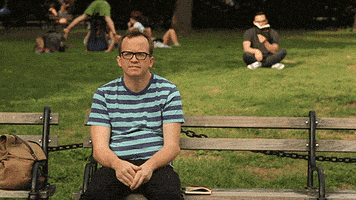 TV gif. From Chris Gethard’s special, Career Suicide, a lonely Chris sits on a park bench when he looks up to see someone waving at him. He timidly waves back and smiles hopefully before realizing that the person is actually waving at a man sitting in the grass behind him. Chris frowns in disappointment.