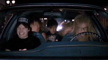 Movie gif. In a car, Mike Myers as Wayne, Dana Carvey as Garth in Wayne's World, and three of their friends bang their heads wildly to the song Bohemian Rhapsody.