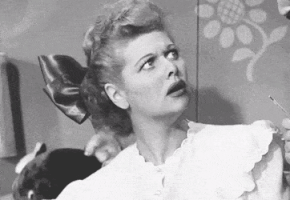TV gif. Lucille Ball in I Love Lucy glances away from someone and curls her lips as she squints her eyes with a look of shock. 