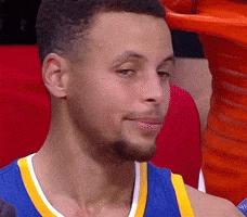 Sports gif. Steph Curry from The Golden State Warriors is sitting on the bench looking incredibly peeved. His mouth is in a grim line and he tightens his jaw as he shakes his head in disapproval while looking away.