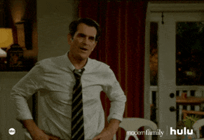 TV gif. Ty Burrell as Phil from Modern Family closes his fists and bends his arms in a "Yes!" motion, bending his knees as he smiles widely and crouches to the ground.