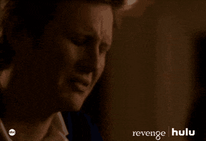 TV gif. Gabriel Mann as Nolan on Revenge lowers his face into his hand, looking upset.