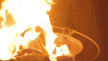 Music video gif. From Radical Face's video for Always Gold, a pile of fabric sits on top of a fire contained in a pit.