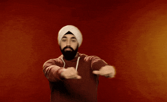 Video gif. Manvir Singh does the cabbage patch dance move in front of a red background.