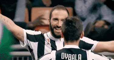 Sports gif . Paulo Dybala and Gonzalo Higuain from "Juventus" hug on the field and then hold their arms out to the crowd in celebration.