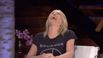 Celebrity gif. Chelsea Handler leaning forward over a table and cracking up.