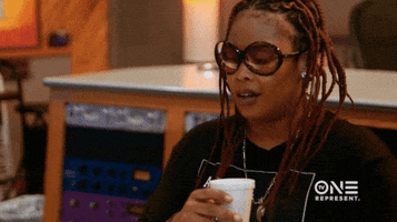 Celebrity gif. Da Brat, wearing sunglasses, dances and shuffles a bit while listening to music, a Styrofoam cup in her hand.