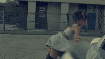 Music Video gif. Rihanna in the We Found Love music video tosses something angrily. She then turns around and stomps away. 