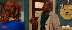 TV gif. Ellie Kemper as Kimmy and Tituss Burgess as Titus in The Unbreakable Kimmy Schmidt stand in front of each other and do a shoulder dance together, ecstatic about something. Titus's lips are pursed and he looks sassy as he dances.