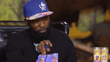 TV gif. Desus Nice points at someone and then points back to his lips like he’s applying chapstick. 