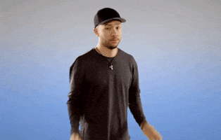 Video gif. A confused man in a baseball cap shrugs, holding up his hands. Text, “IDK?”