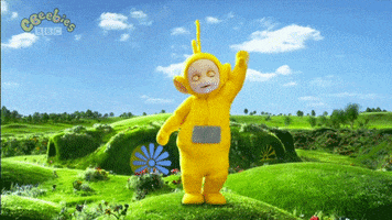 TV gif. Laa Laa the yellow and Po the red Teletubby dance happily on green hilltops. 