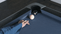 A cue stick sticking out of a shirtsleeve sinking a ball. The hand then shows a thumbs up.