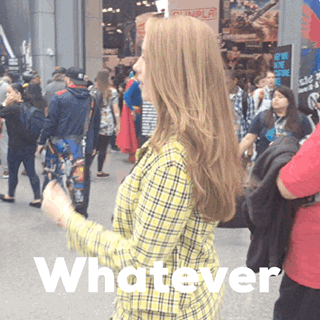 Video gif. A woman cosplaying as Cher from Clueless. She has the same pantsuit and tosses her hair over her shoulders, smiling at us and saying, "Whatever."