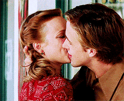 Movie gif. Ryan Gosling as Noah and Rachel McAdams as Allie in The Notebook. The two of them are hugging and kissing outside of a store and Noah grabs Allie to rub his face all over her and she yelps as she laughs and slides down.